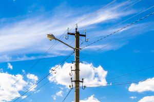 Power line pole against blue sky